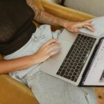 Person researching market trends on a laptop, exploring strategies to identify and fill consumer needs in 2025.